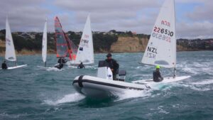 electric boat - Cormorant Electric 490 with ZeroJet 30kW electric jet propulsion system - powers through water with sailing dinghies in backgorund