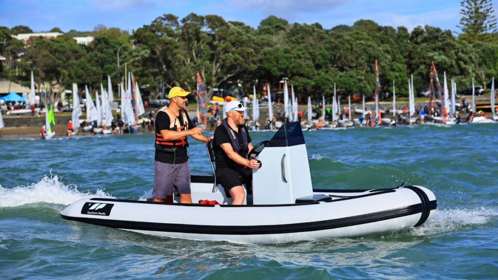 Two male sailors onboard electric RIB in sailboat regatta