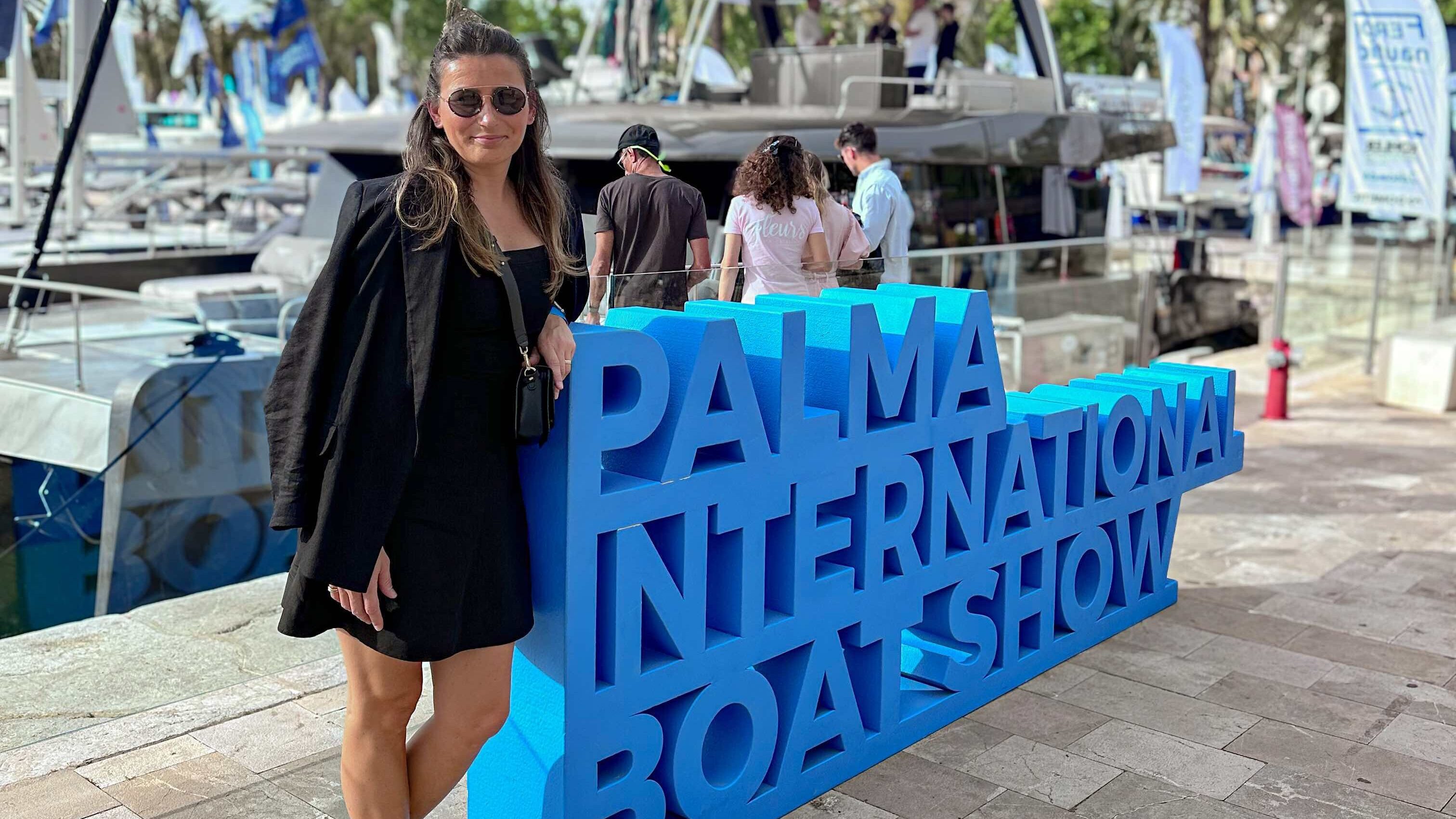 Olga Skronska stands beside a Palma Boat Show sign