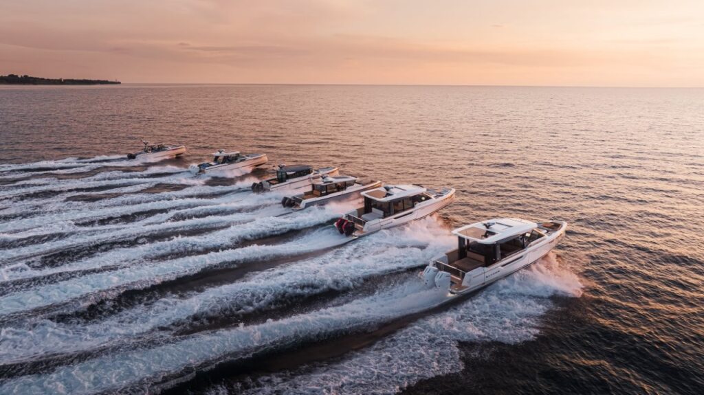 fleet of motor boats riding across water