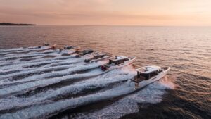 fleet of motor boats riding across water