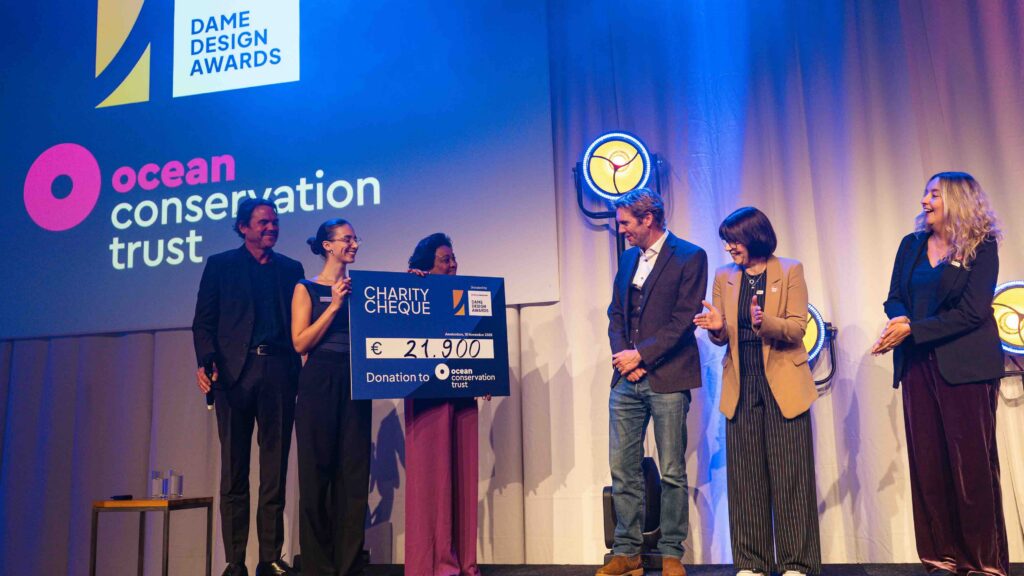 group holding large cheque on stage at presentation