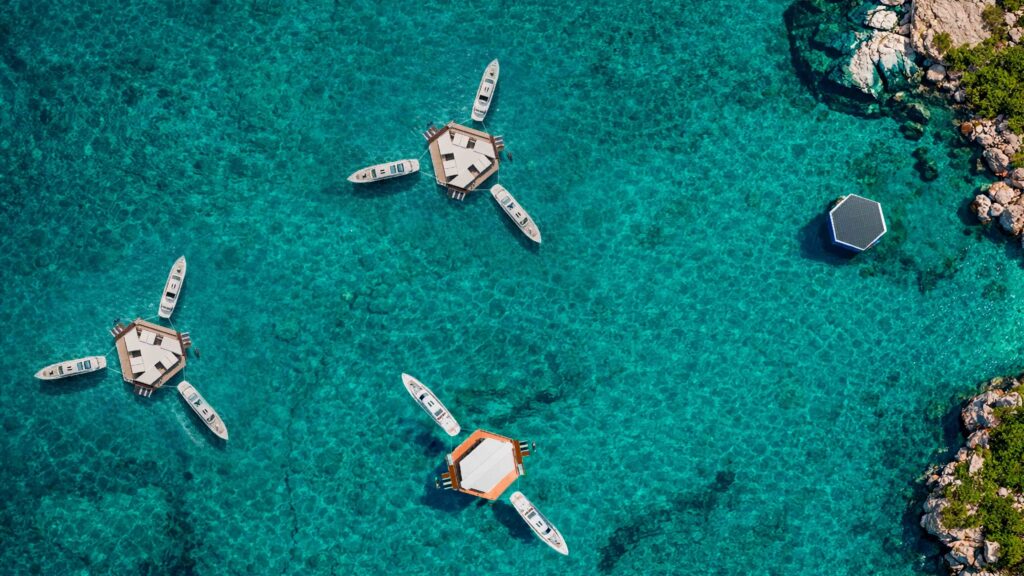 Aerial view of modern floating hubs with boats acnhored off