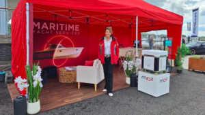 Fiona Pascoe from Maritime Yacht Services stands outside a red booth