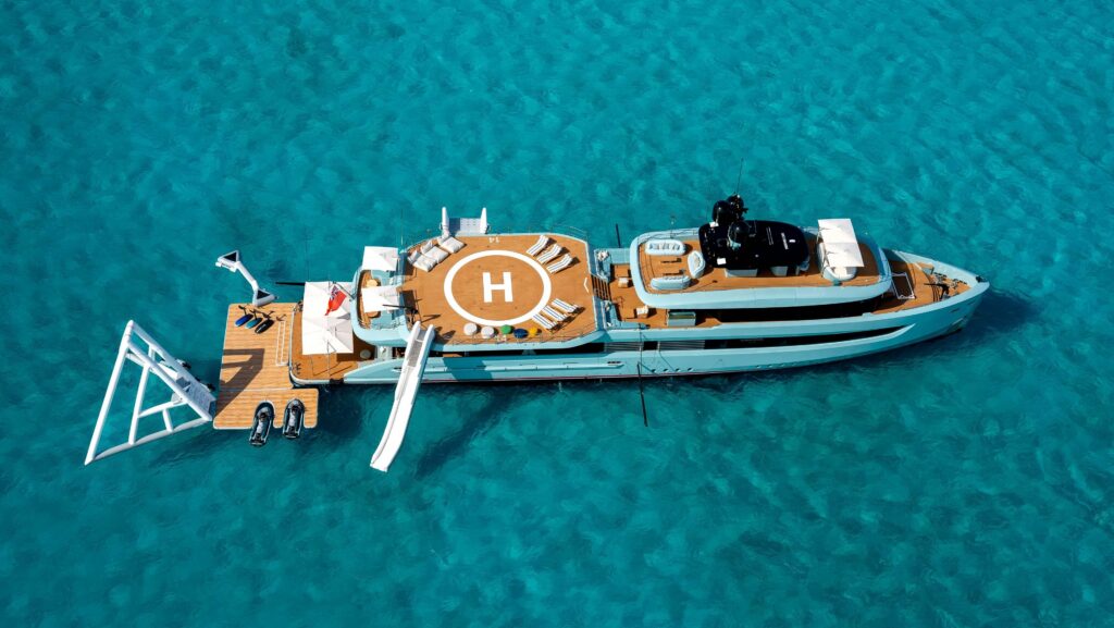 aerial view of superyacht with inflatable slides and helipad