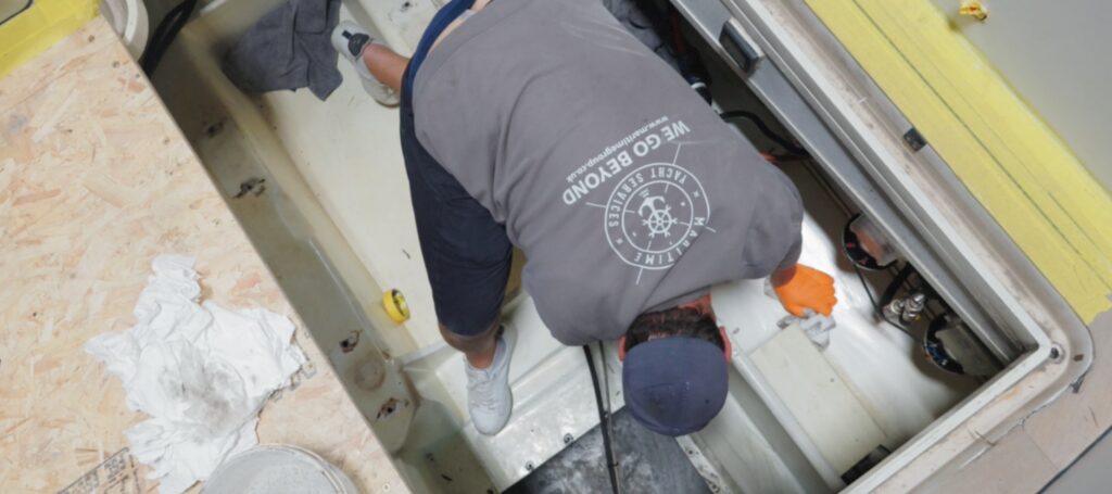 Maritime Yacht Services boatbuilder working on boat - aerial image shows back