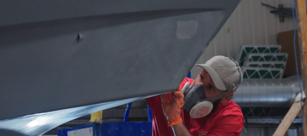 Maritime Yacht Services =- boatbuilder stands under hull