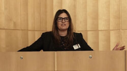 Sarah Wallbank August Race behind a lectern