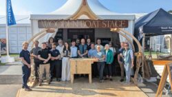 Group of people infront of Wooden Boatbuilding stage