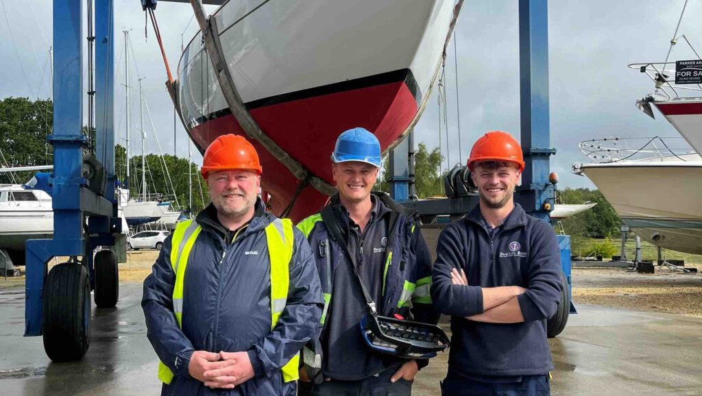 three workmen at boatyard