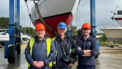 three workmen at boatyard