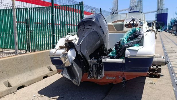boat in a car park with outboard on stern