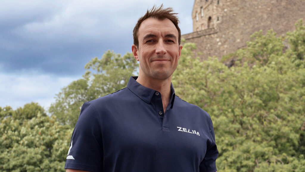 man in navy polo top smiling