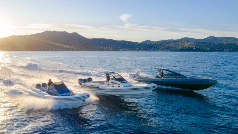 three Lomac rigid inflatable RIBs on water with mountains in background