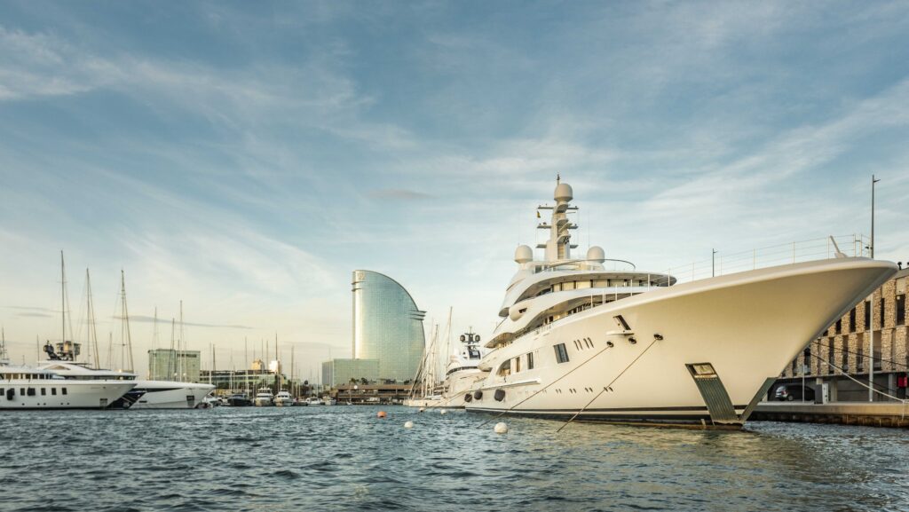 superyacht in marina with modern buildings behind