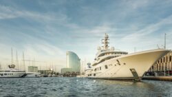 superyacht in marina with modern buildings behind
