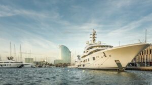 superyacht in marina with modern buildings behind