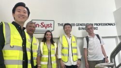 En-Syst team in front of logo