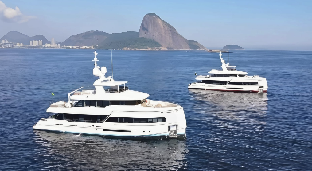two white superyachts at anchor over blue seas