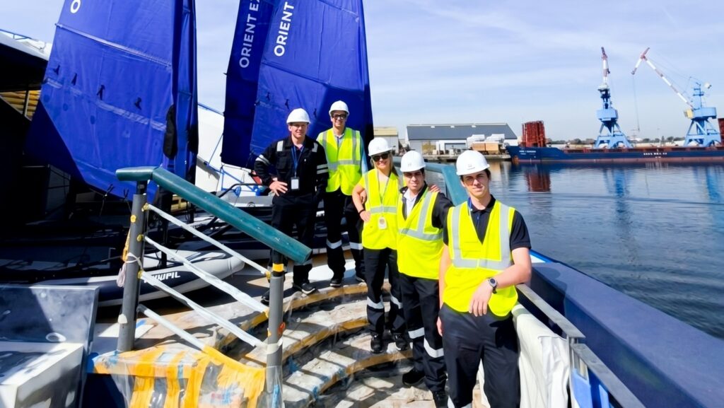 a group of male workers stand on the stern of a cruise ship