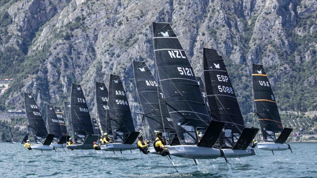 Fleet of performance racing foiling yachts with black sails
