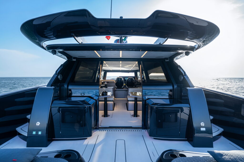 View from the aft deck into the saloon of the BRABUS ULTIMA 55, showing seating areas and the helm station.