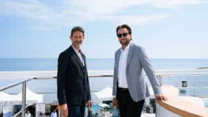 two men in suits at bow of large yacht
