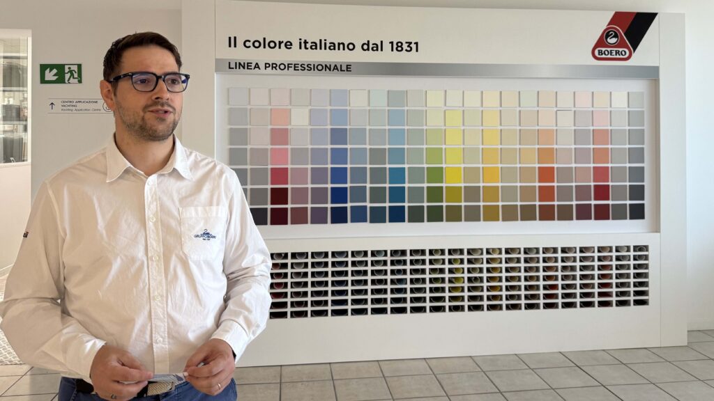 man stands before colour charts on wall