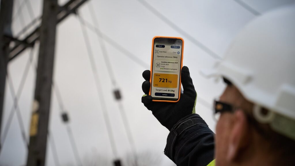 man holding smartphone up to sail rigging