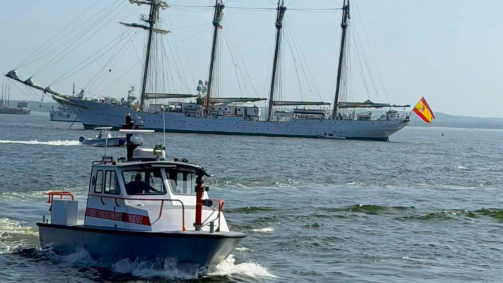 rescue boat in front of tall ship before being hit by a whale
