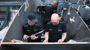 Team of three boat engineers at work
