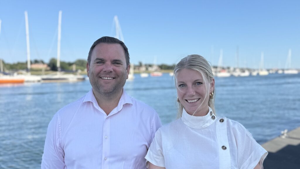women and man at a marina in white shirts
