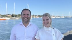 women and man at a marina in white shirts