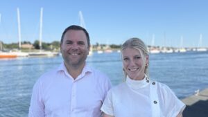 women and man at a marina in white shirts