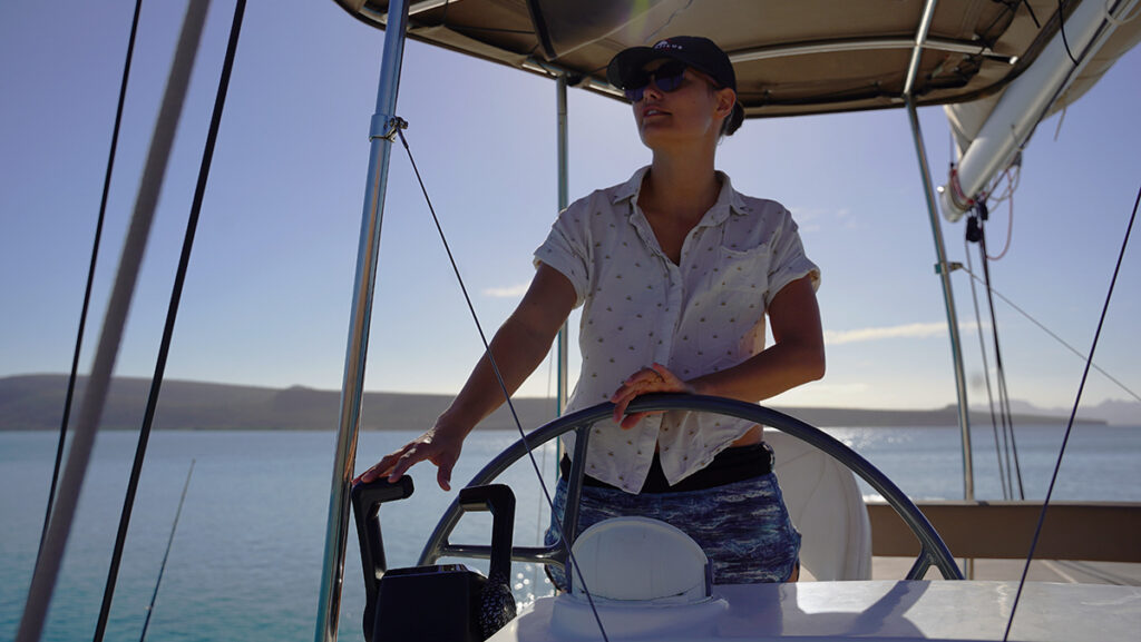 sailor at helm of boat - it's Nautilus Sailing