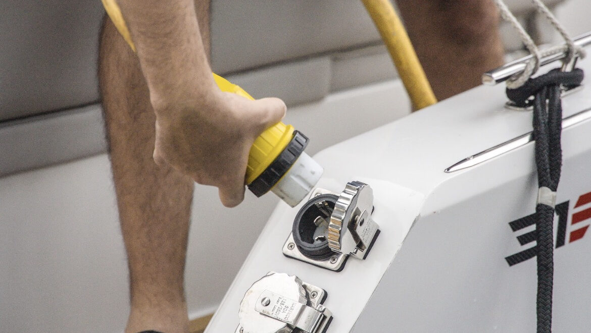 electric plug in from Vision Marine - hand plugs electric cable into boat