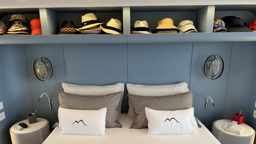 hats above a bed on Arcadia interior A80