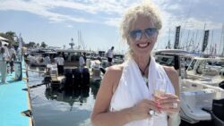 lady with glass of champagne in front of boats