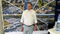 man stands in front of pictures of marinas