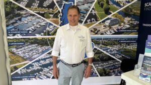 man stands in front of pictures of marinas