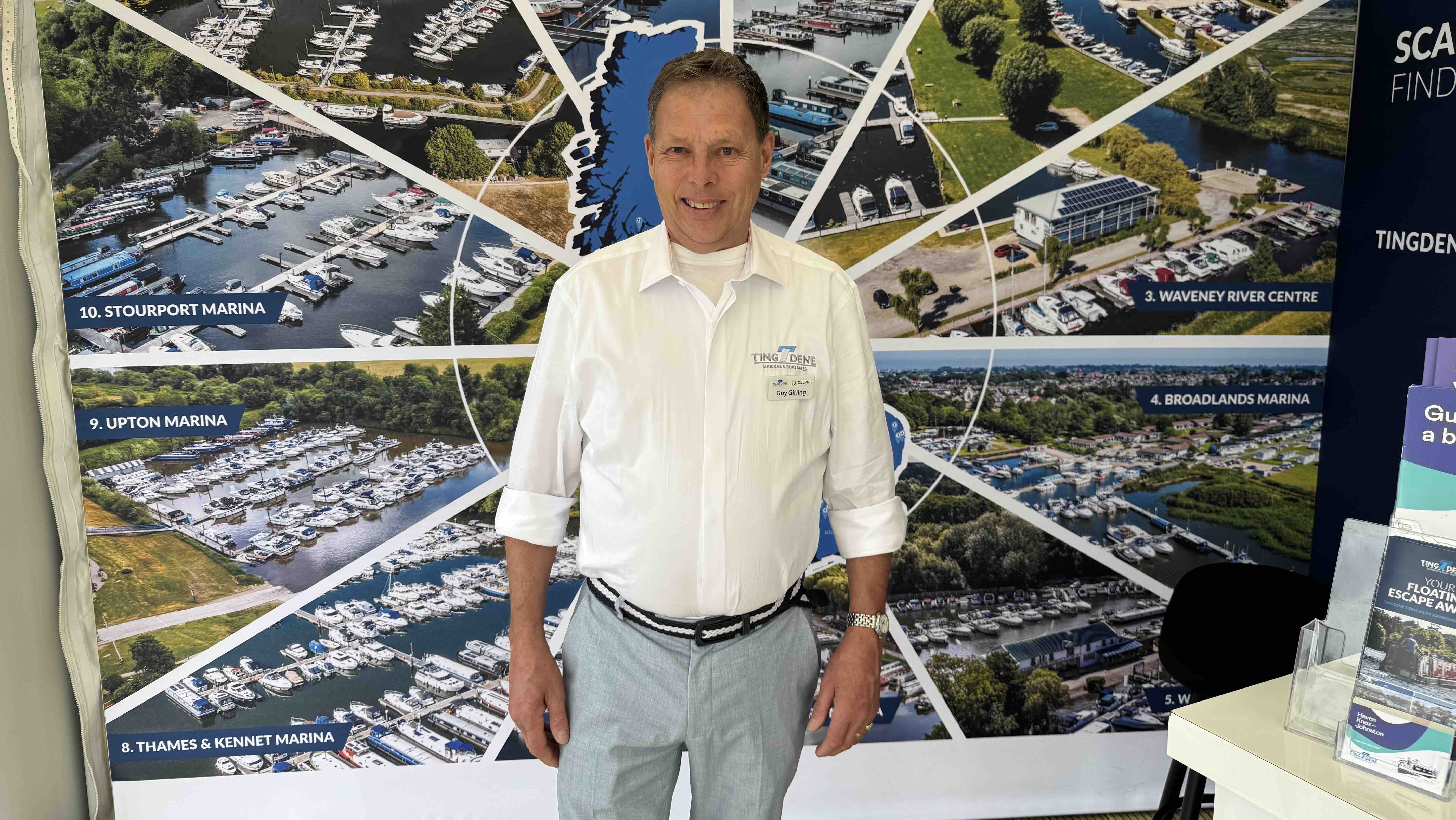 man stands in front of pictures of marinas