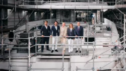 five business people standing on back of superyacht in build