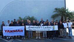 Team stands outside a building holding flags