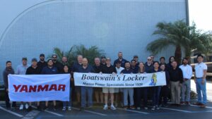 Team stands outside a building holding flags
